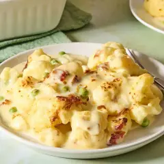 Zapiekany kalafior z groszkiem i boczkiem w kremowym sosie. Idealny pomysł na kolację na szybko.