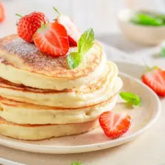 Puszyste pancakes z truskawkami i miętą, idealne na śniadanie. Prosty przepis na pyszne placki.