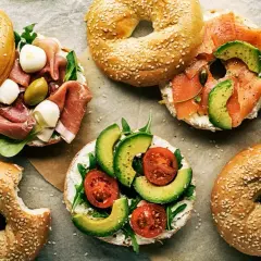 Pyszne bajgle z łososiem, awokado, pomidorkami, mozzarellą i szynką. Idealne co zamiast chleba na śniadanie lub lunch.
